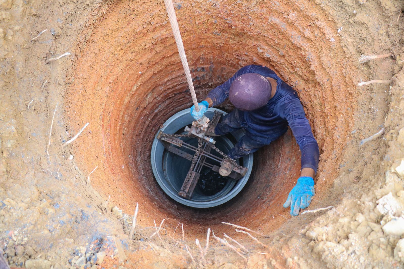 Technician working inside a borehole casing